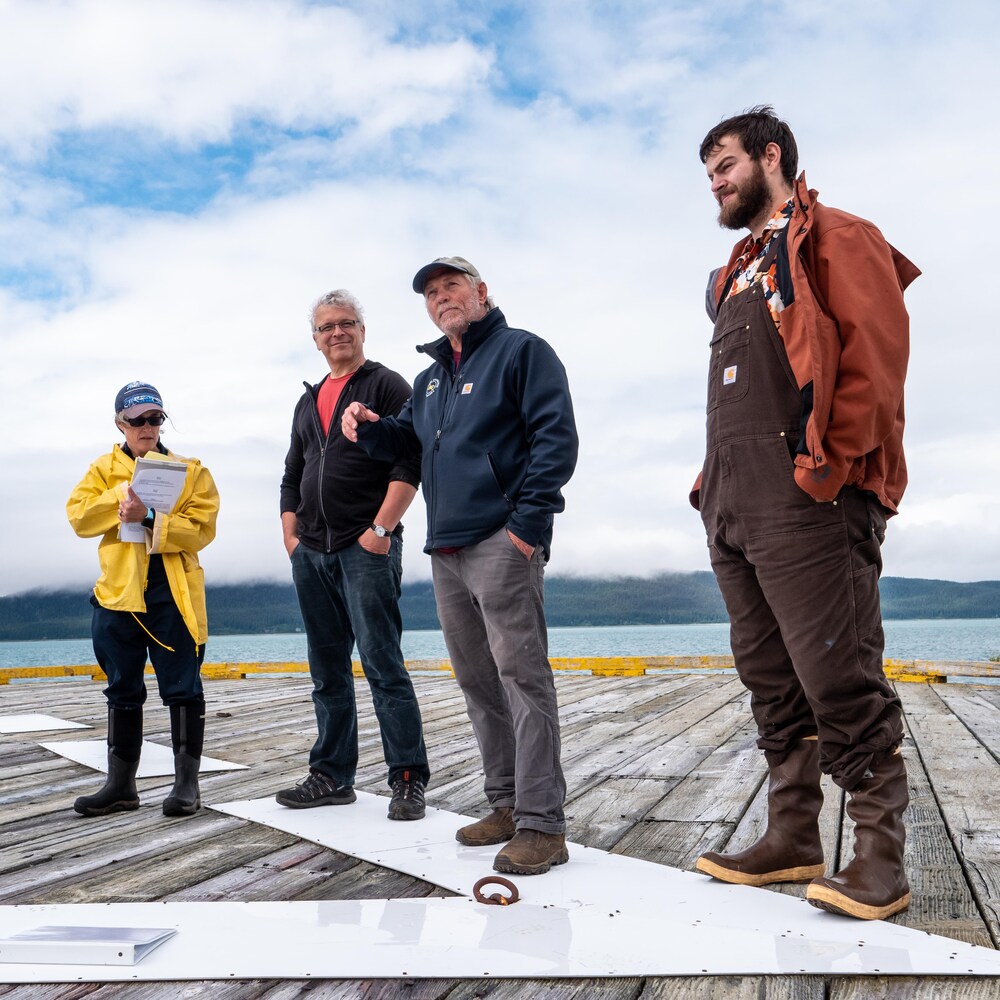 Quatre membres de l'Association pour la préservation du phare d'Eldred Rock se tiennent sur le ponton du phare.