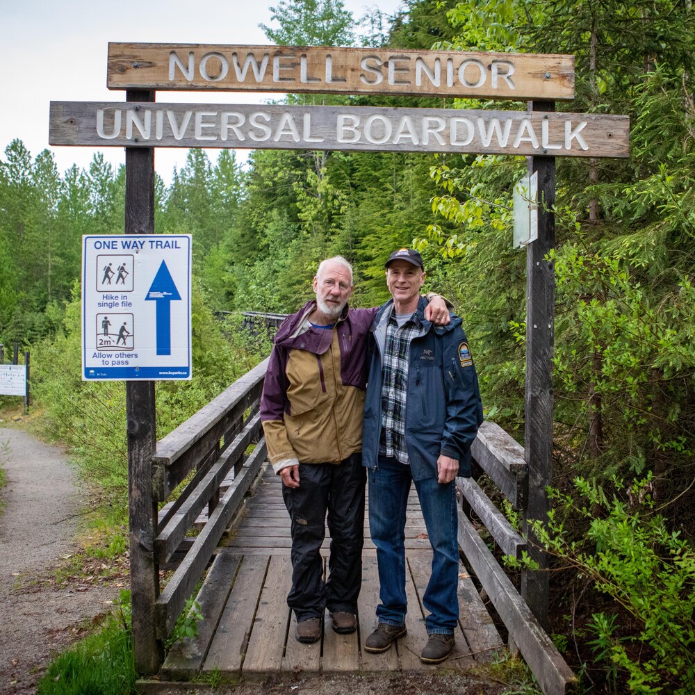 Nowell Senior (à gauche) et Mikel Leclerc (à droite) au début d'un sentier en bois qui donne sur la forêt du parc Chun T'oh Whudujut, en Colombie-Britannique, en juin 2022.