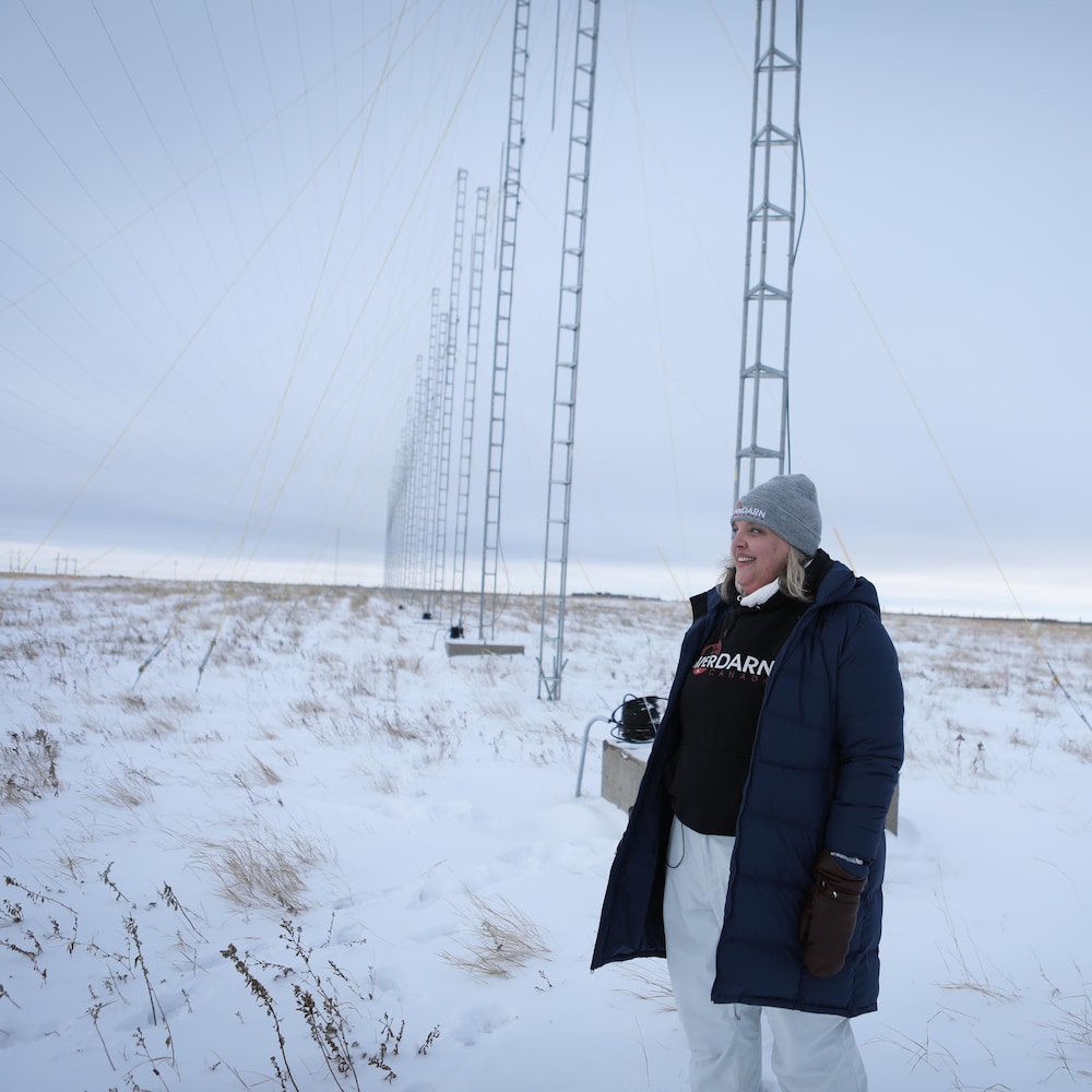 Kathryn McWilliams dans un champ enneigé, entourée d'antennes, près de Saskatoon, en février 2024. 