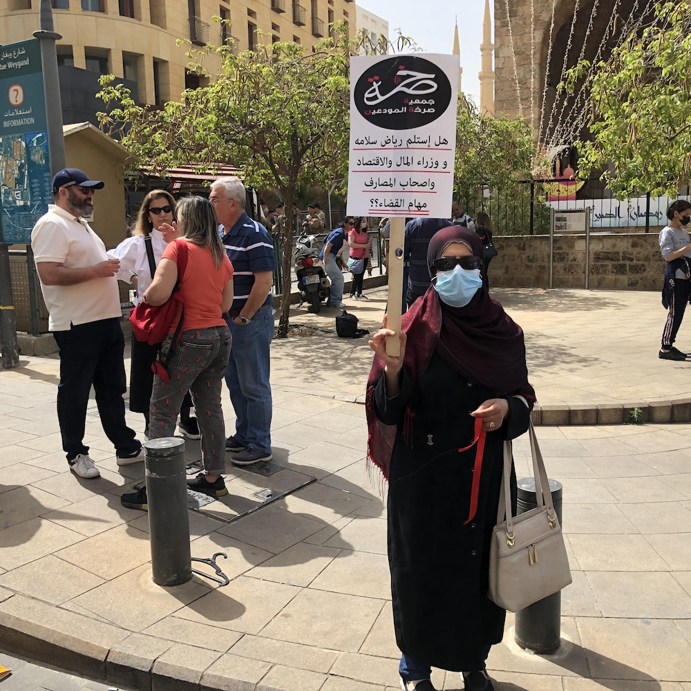 Une femme voilée avec une affiche manifeste au centre ville de Beyrouth.