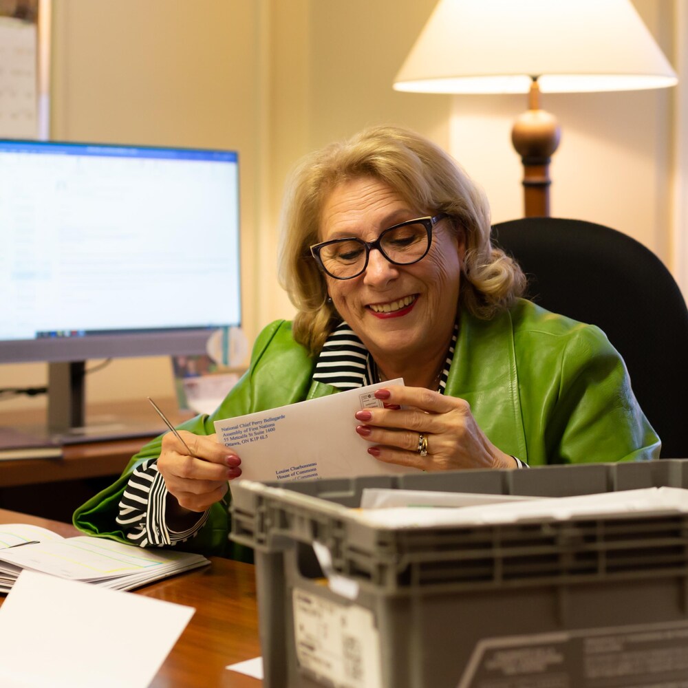 La députée qui ouvre une lettre à son bureau d'Ottawa.