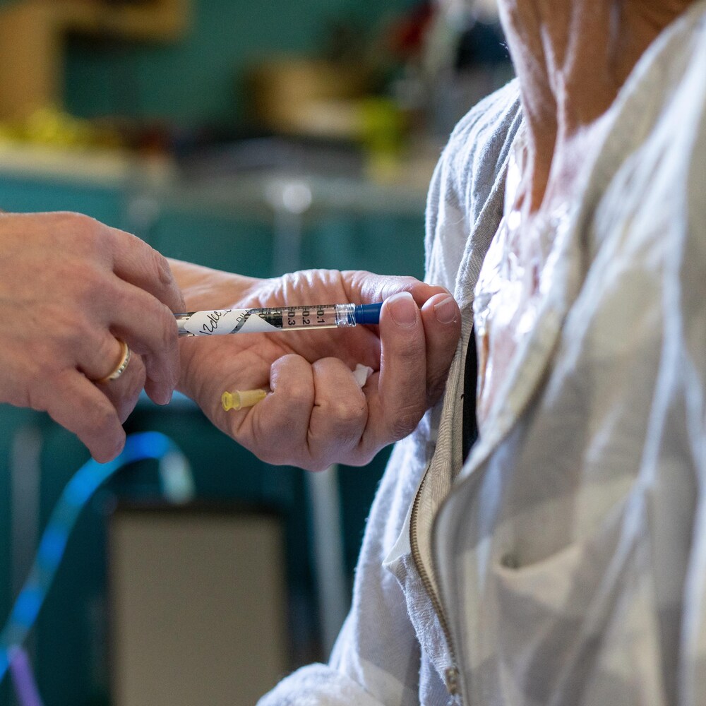 Un médicament est injecté avec une seringue dans un cathéter.