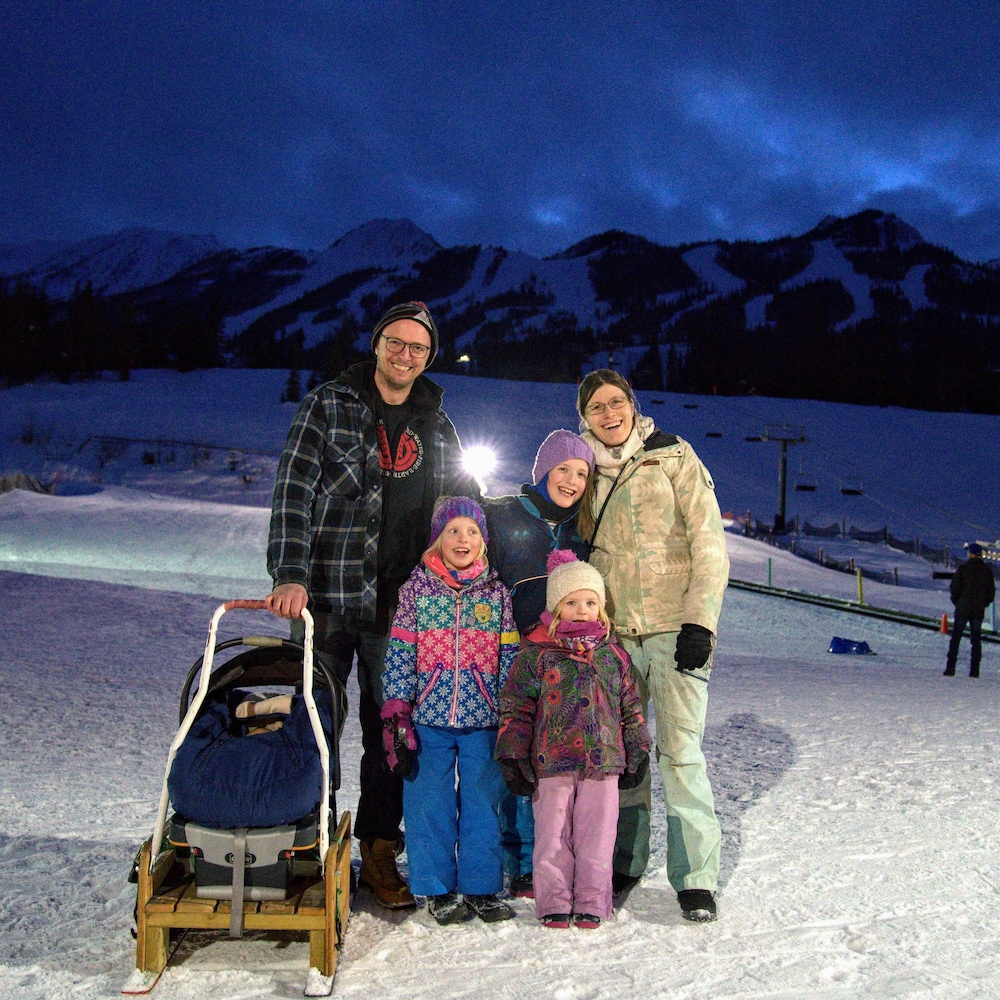 La famille Rousseaux le soir dehors dans une station de ski.