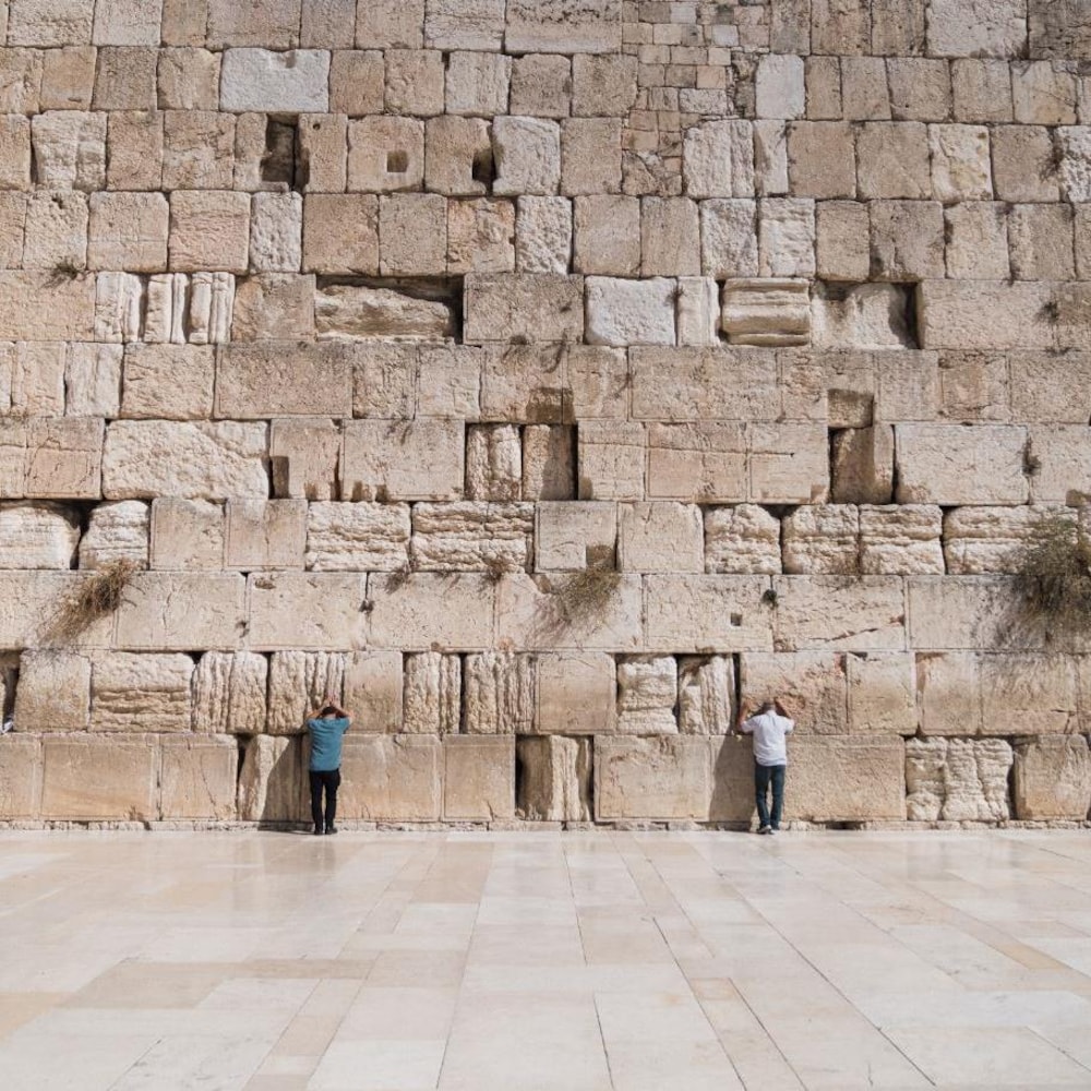Deux hommes prient devant le mur des Lamentations.