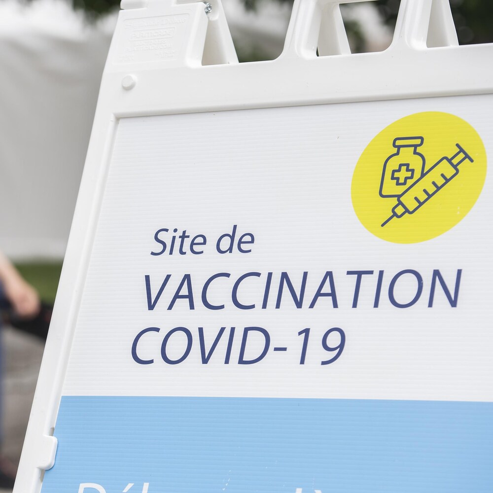 Une pancarte est installée devant une clinique de vaccination.