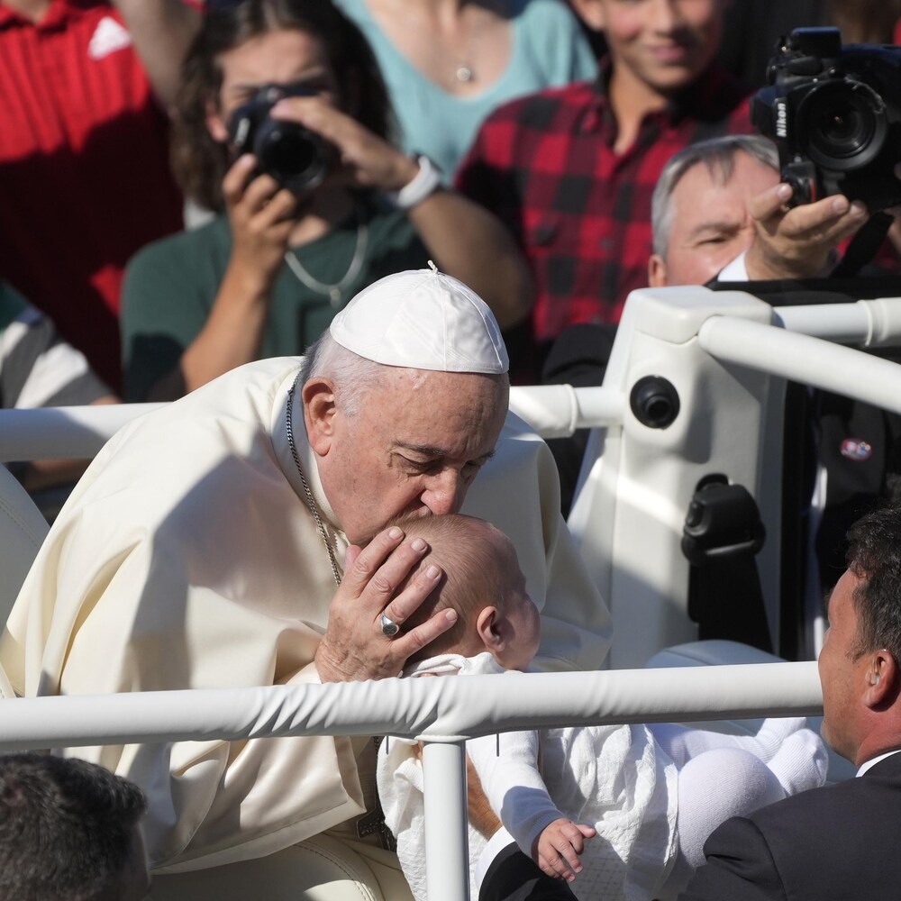 Le pape François embrasse un enfant.