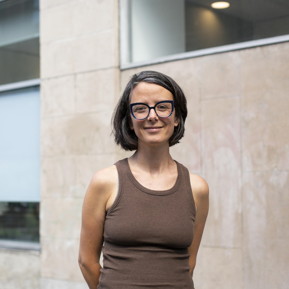 Portrait de Taïka Baillargeon, directrice adjointe des politiques chez Héritage Montréal, devant un mur de briques.