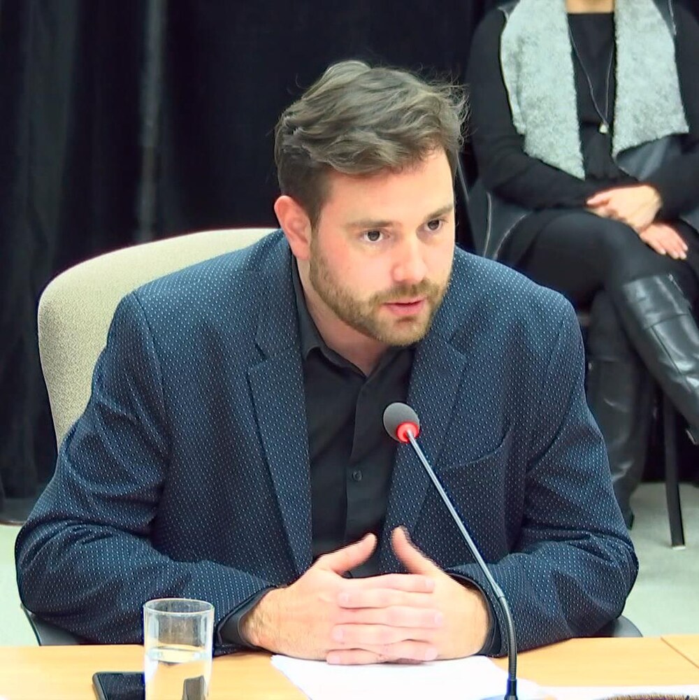 Un homme témoigne lors d'une commission d'enquête.