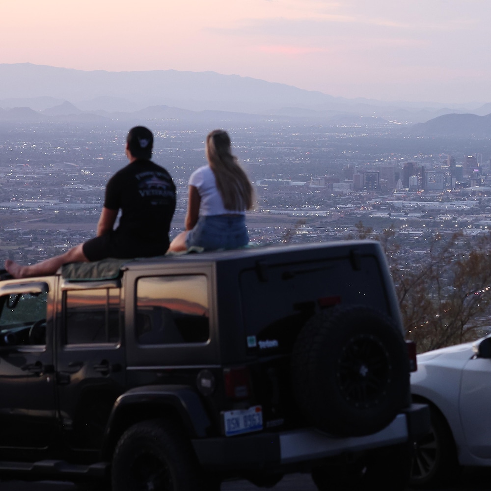 Des automobilistes réunis à South Mountain Park après le coucher du soleil.
