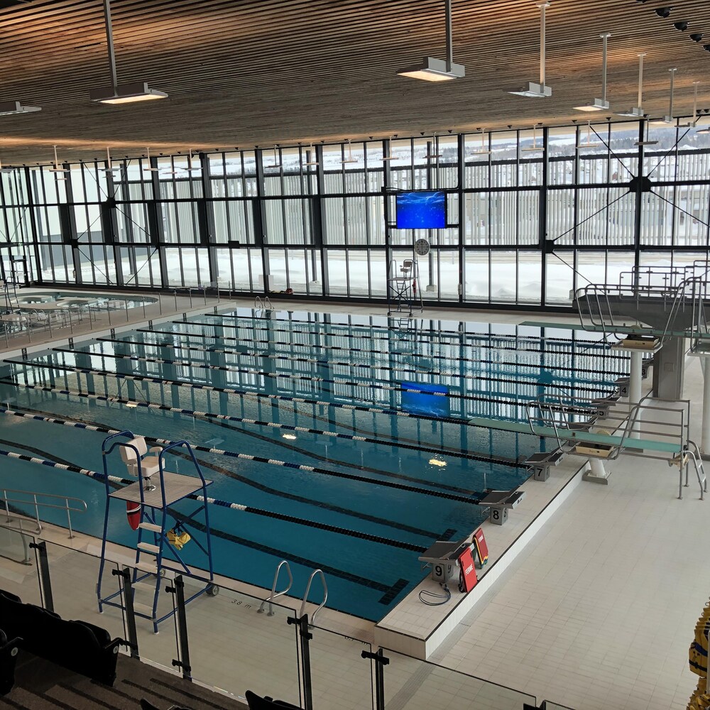On voit une grande piscine intérieure qui reprend les balises de la piscine olympique avec des tremplins et des corridors en longueur. Derrière elle se trouve une autre zone piscines avec des bassins à remous.