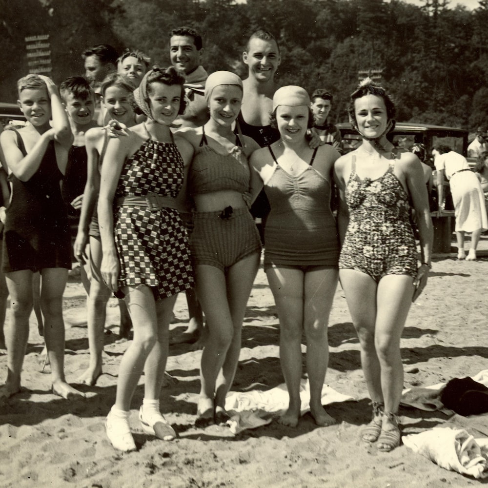 Des baigneuses sur leur 31 devant le stationnement de la plage à la fin des années 1930.