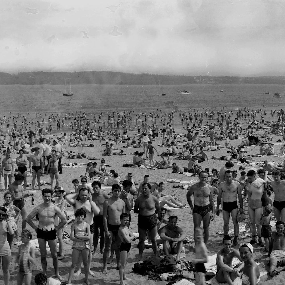 Un montage à 180 degrés montrant la plage de l'Anse-au-Foulon couverte de baigneurs, le 1er juillet 1955.