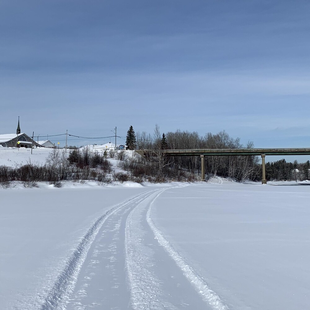 Le pont enjambe la rivière gelée.