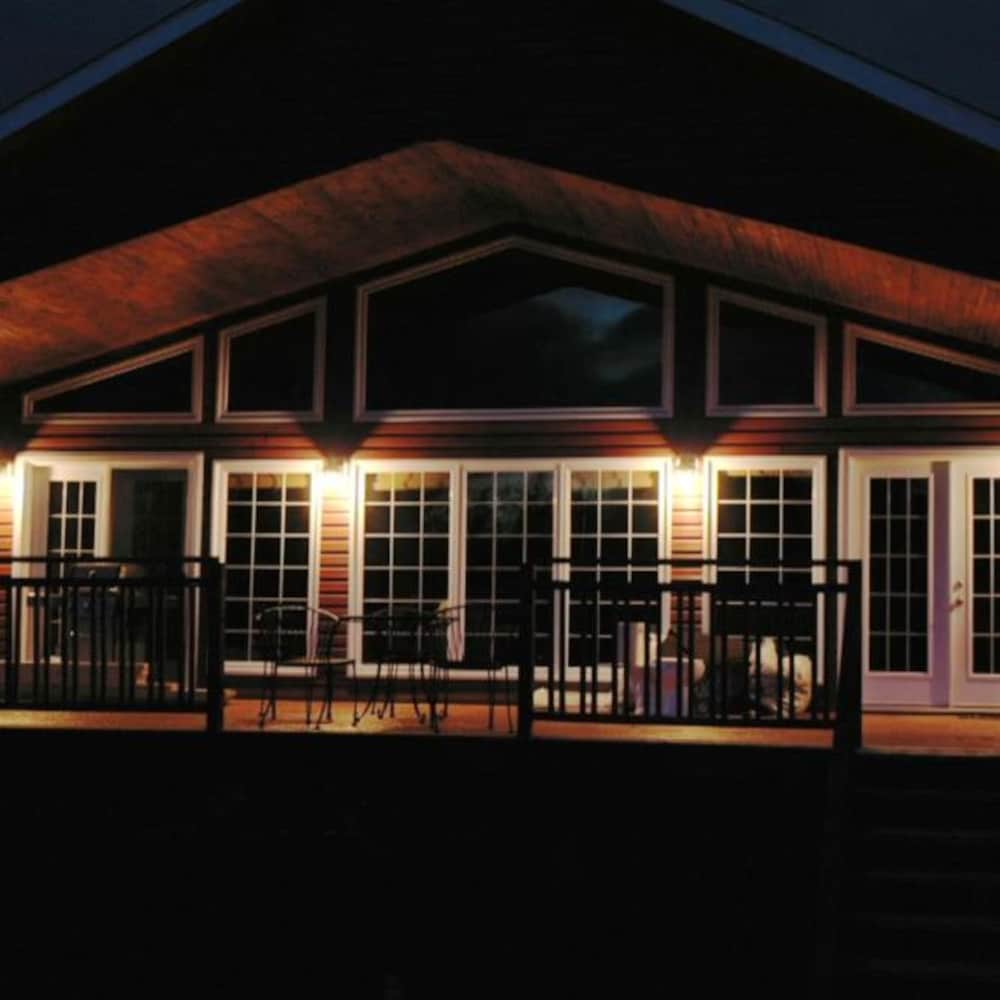 Une maison éclairée, à la tombée de la nuit.