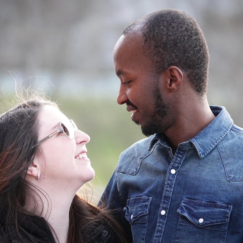 Un homme et une femme se regardent en souriant.