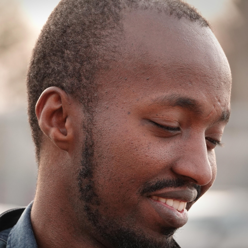 Un homme souriant de profil.