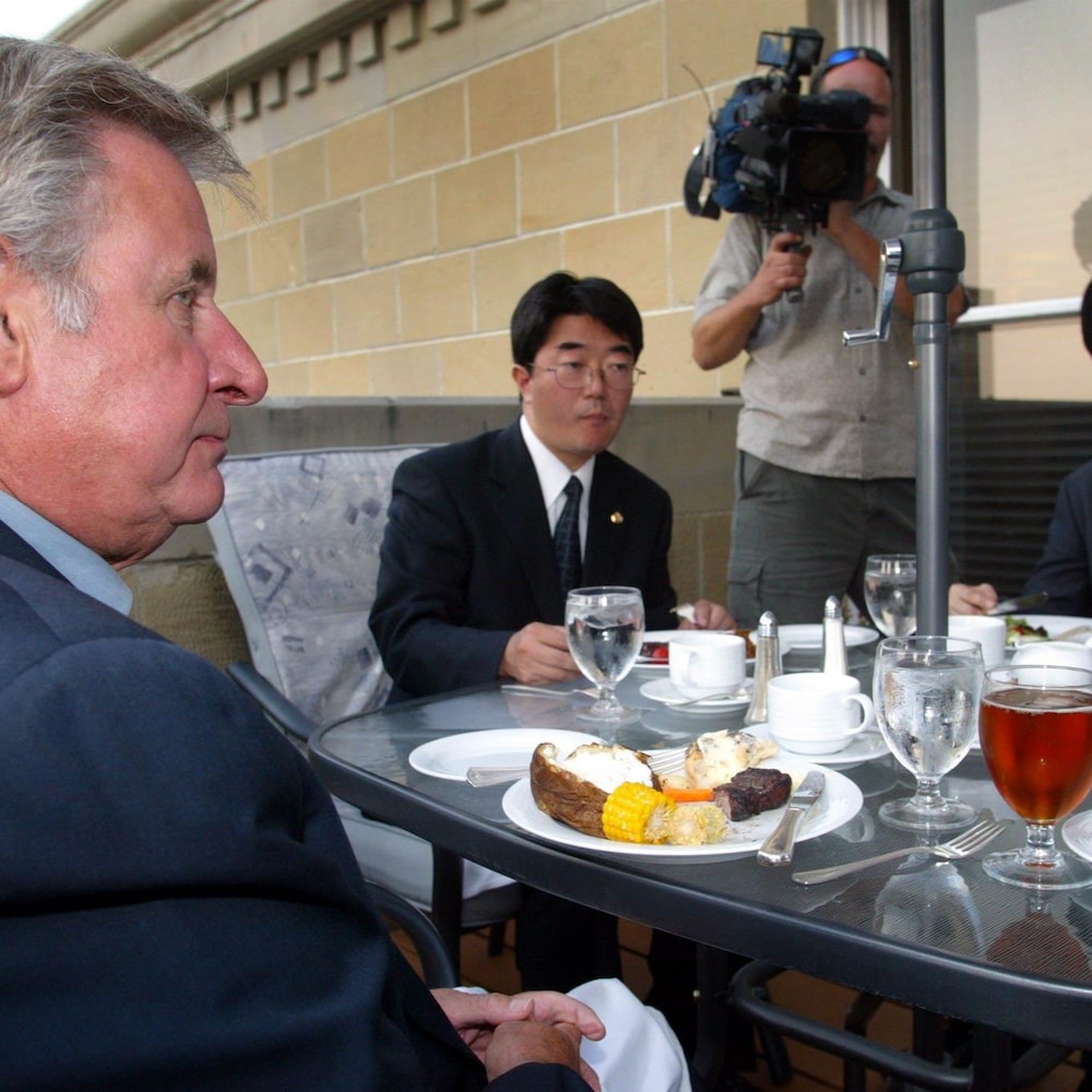Ralph Klein assis à table. 