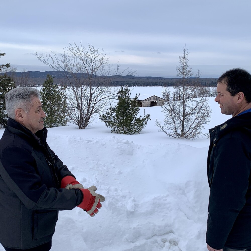 Réal Mercier met des gants pendant que son fils, Stéphane, le regarde en souriant.
