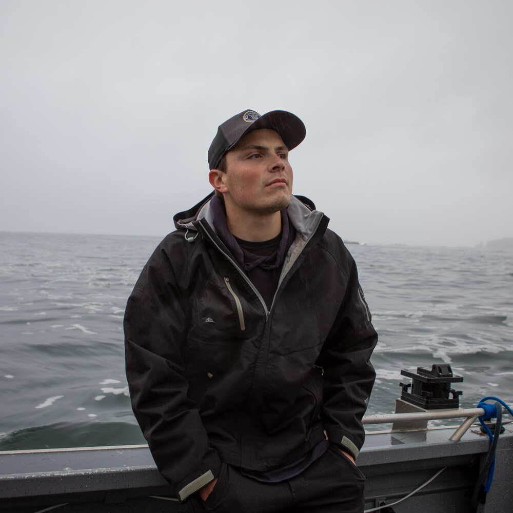 Riley Richardson accoté dans un bateau sur l'eau, près de l’île Nootka, en Colombie-Britannique, fin octobre 2023.
