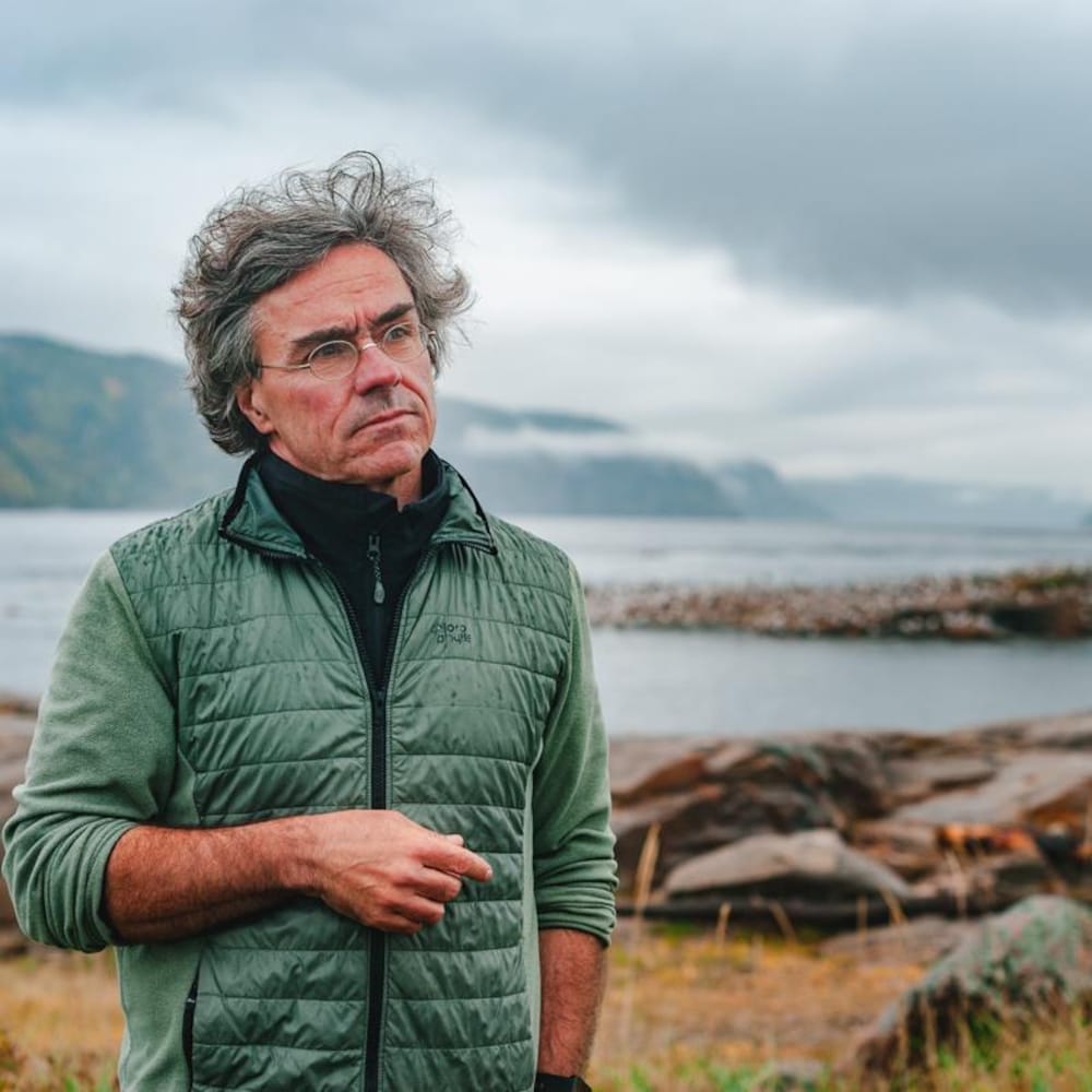 Robert Michaud regarde au loin sur le rivage à Tadoussac.