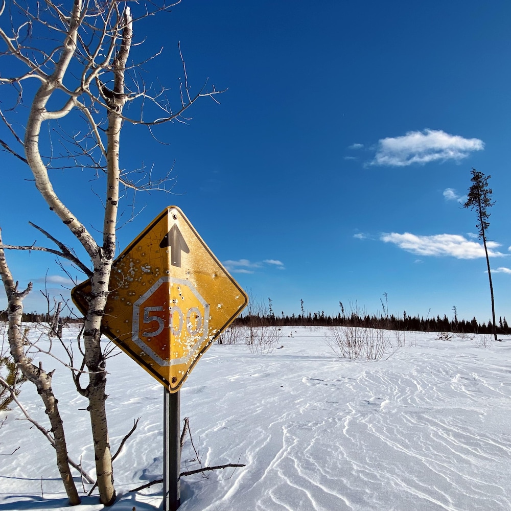 Une signalisation routière indique un arrêt dans 500 mètres.