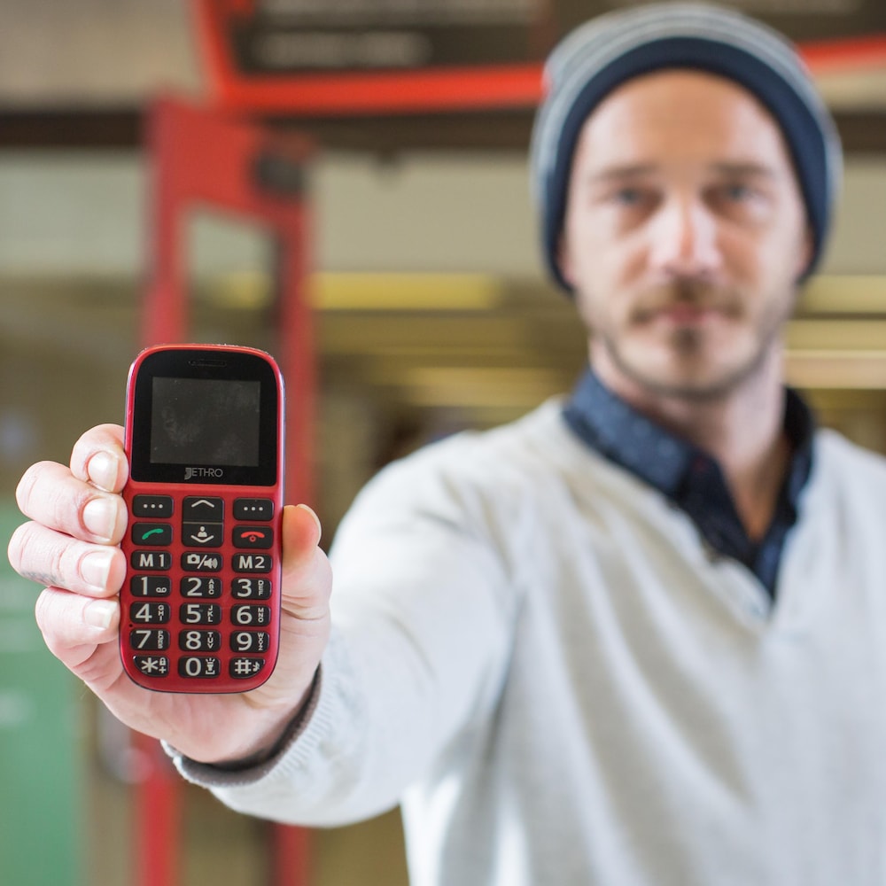 Samuel Veissière montre son téléphone cellulaire à pavé numérique à la caméra.