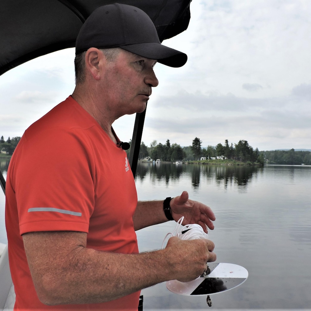 Michel tenant un disque pour mesurer la transparence de l'eau.