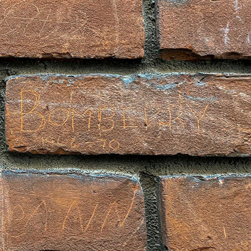 Son nom, gravé en 1970, est toujours bien lisible dans la brique
