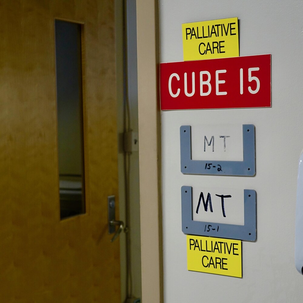 À l’extérieur d’une chambre, des affiches indiquent que cet espace est réservé aux soins palliatifs


