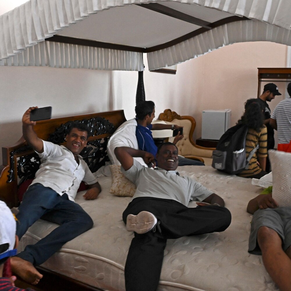 Des Sri-lankais se photographient sur le lit du palais présidentiel.