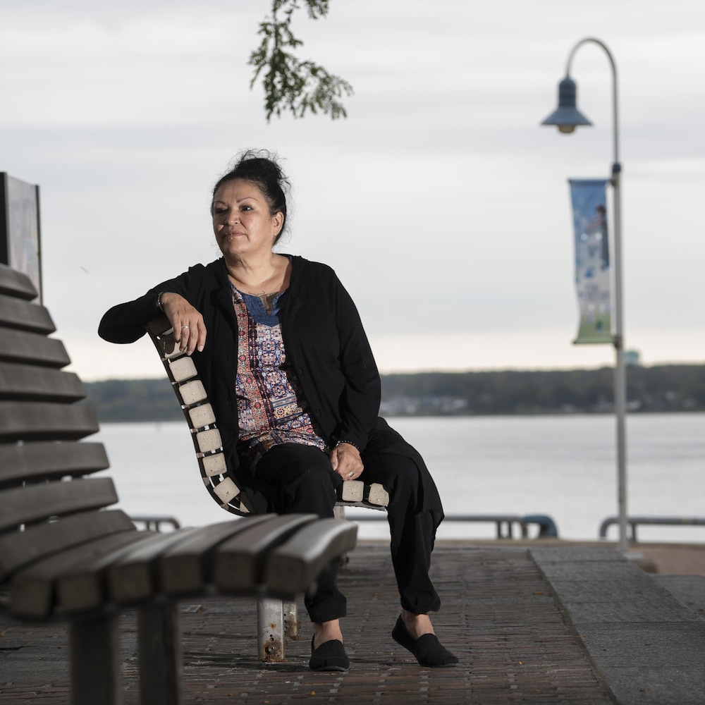 Nicole Awashish assise sur un banc de parc.