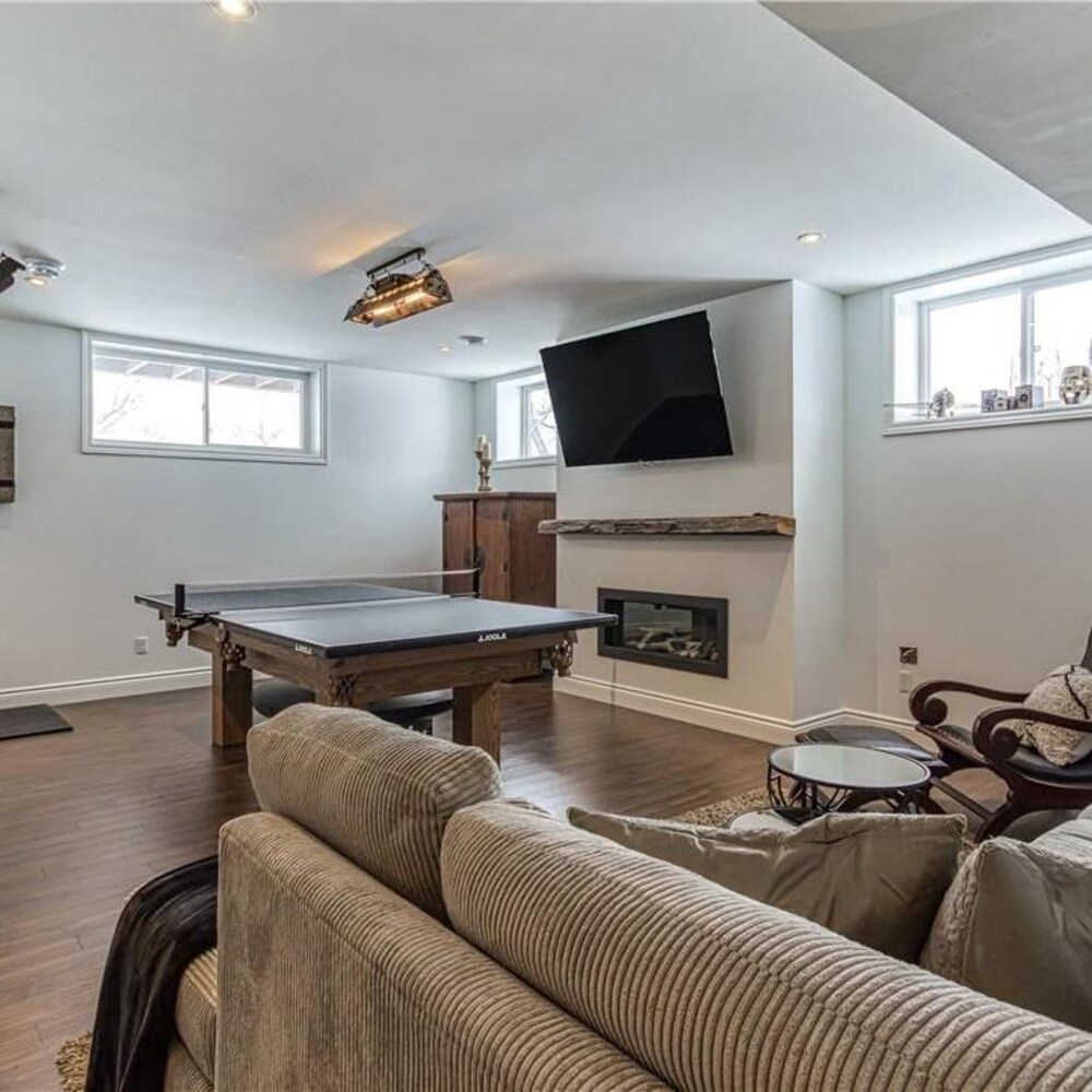 Un sous-sol aménagé avec une table de ping-pong