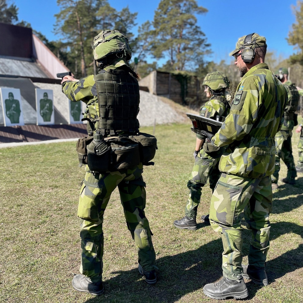 Arms in hand, a soldier aims at a target.