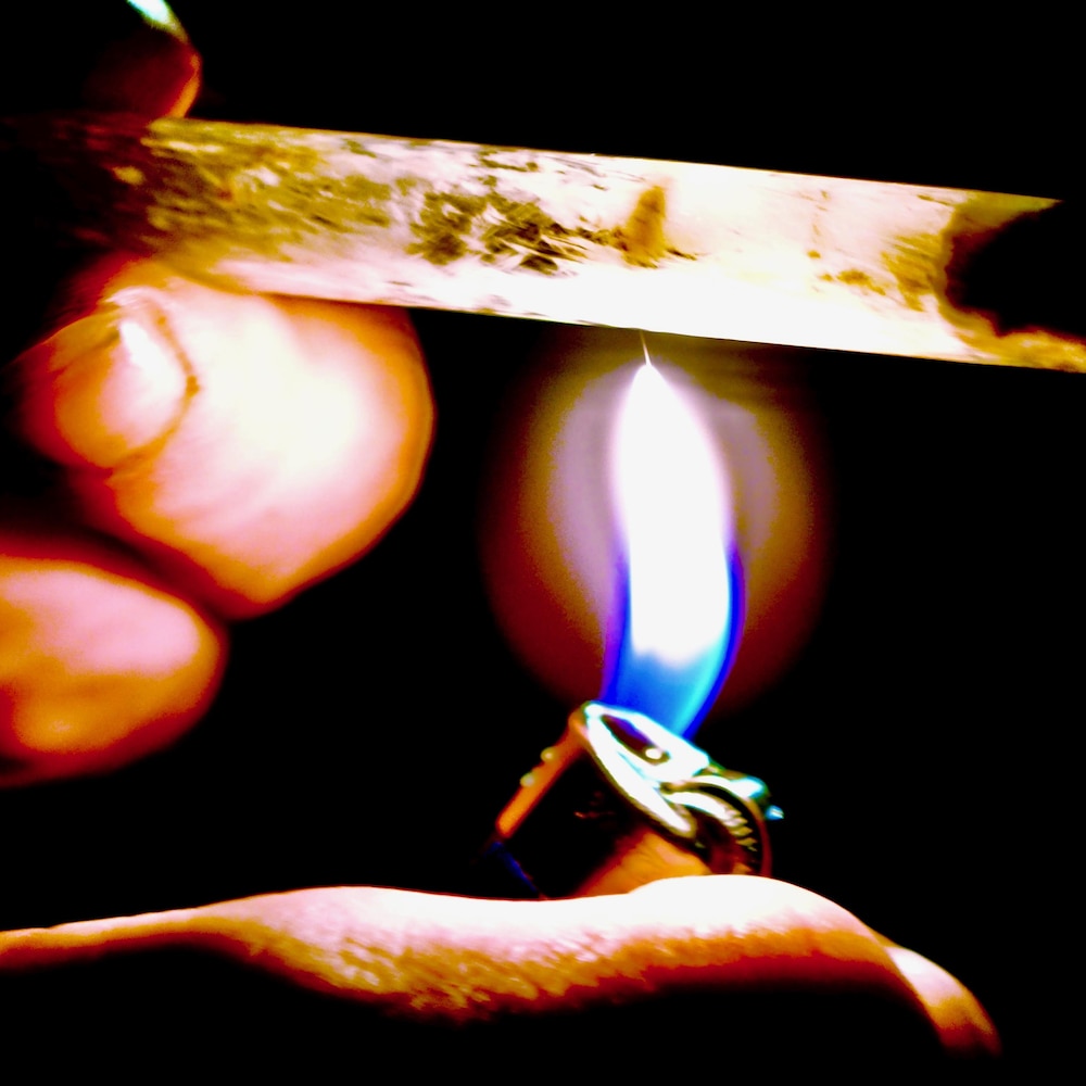 Une flamme chauffe un petit tube.