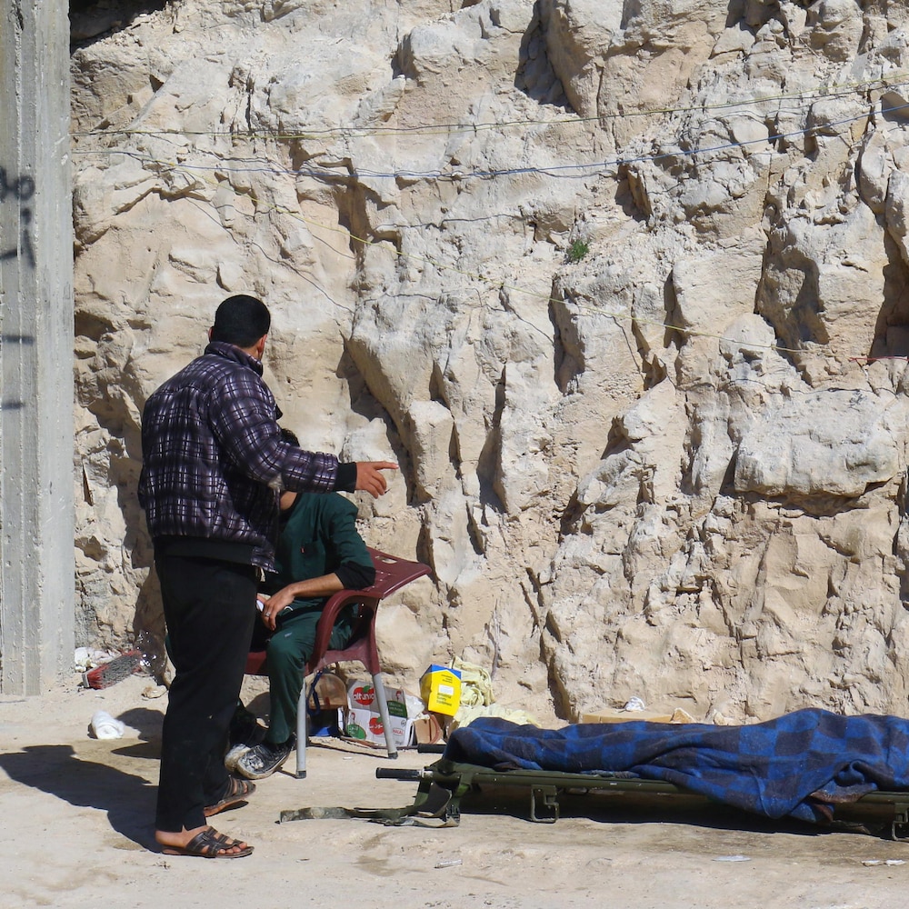 Des gens se tiennent près d'un corps inerte, victime d'une possible attaque au gaz près d'Idlib en Syrie.