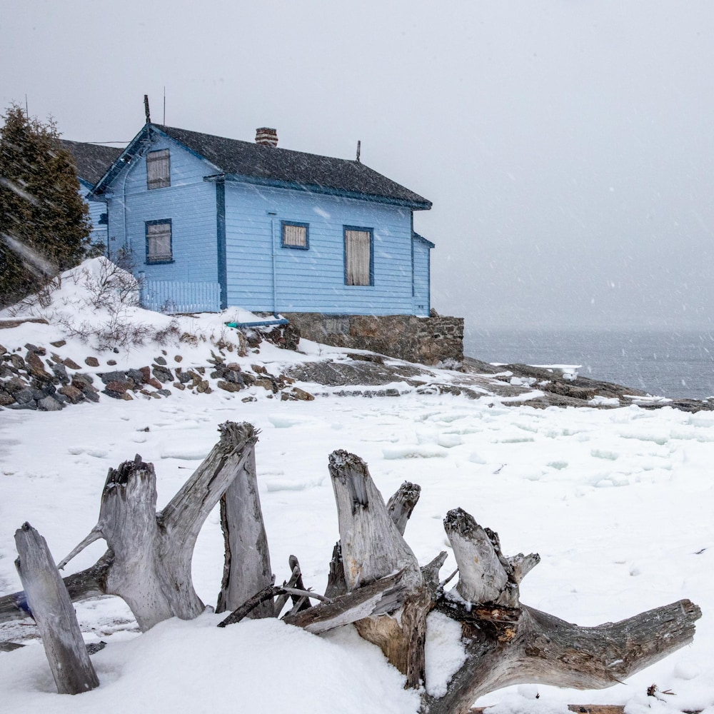 Une maison au bord du Saint-Laurent sous la neige.