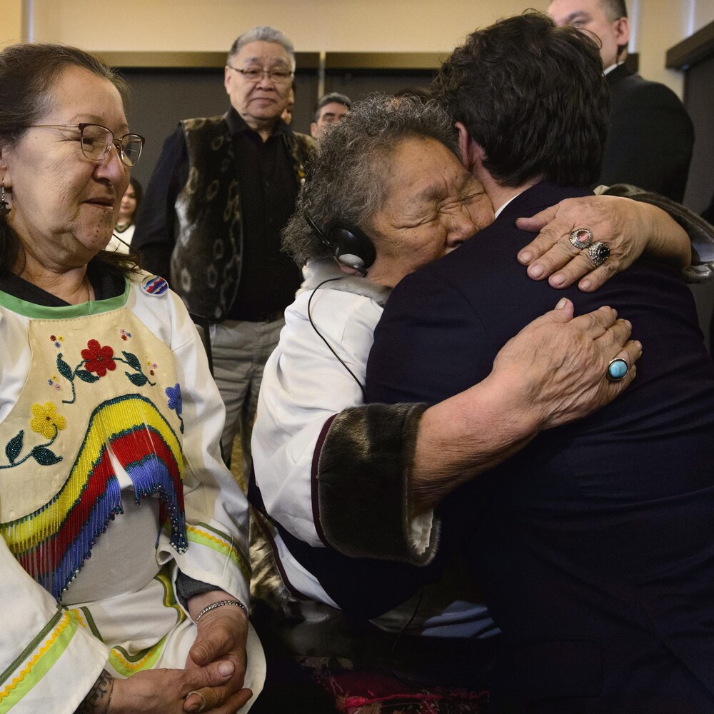 Le premier ministre Justin Trudeau est embrassé par une aînée inuk, Alacie Joamie.