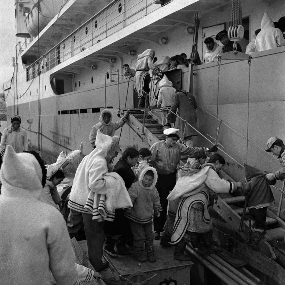 Des Inuit montent à bord du C.D. Howe, un navire-clinique du gouvernement  canadien.