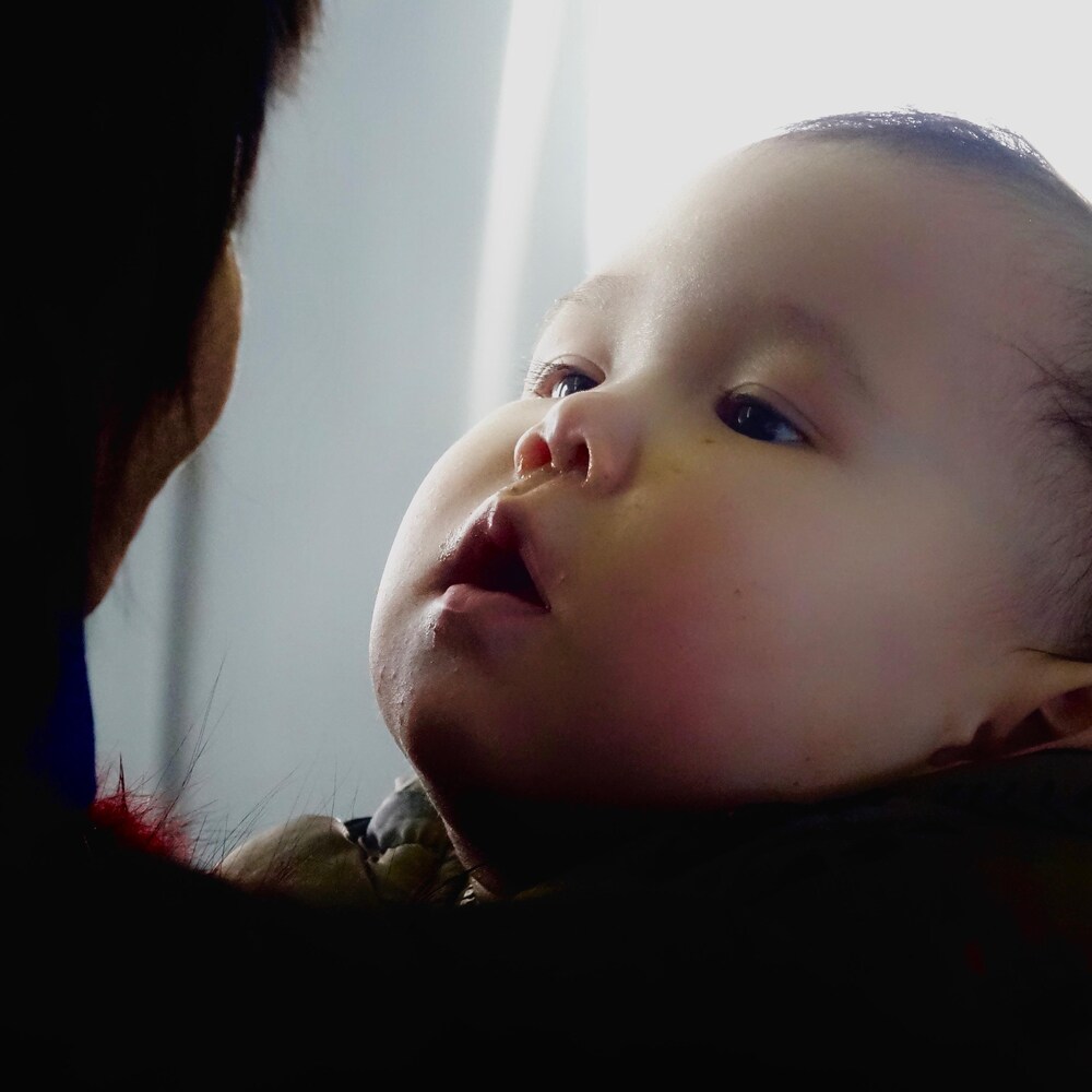 Un bébé regarde sa mère. 