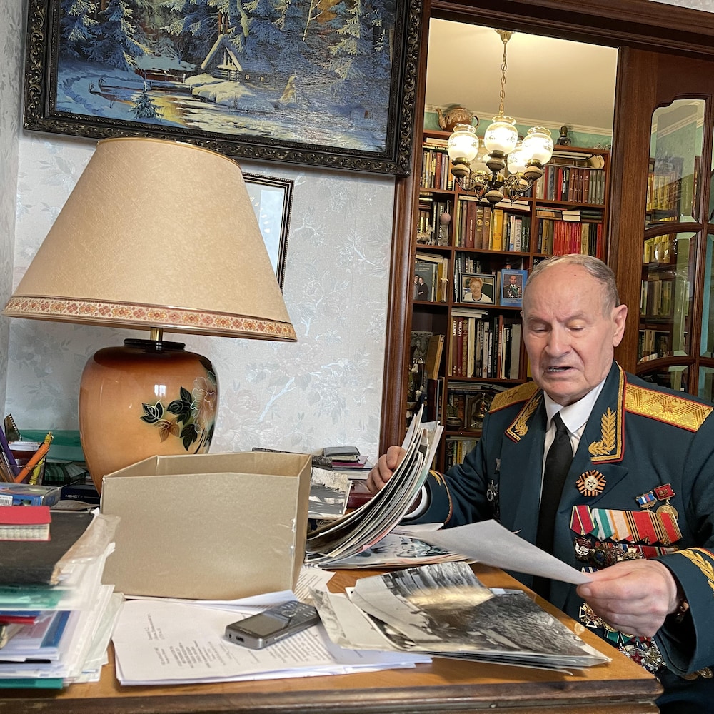 Le général Tarakanov assis à une table consulte des documents.