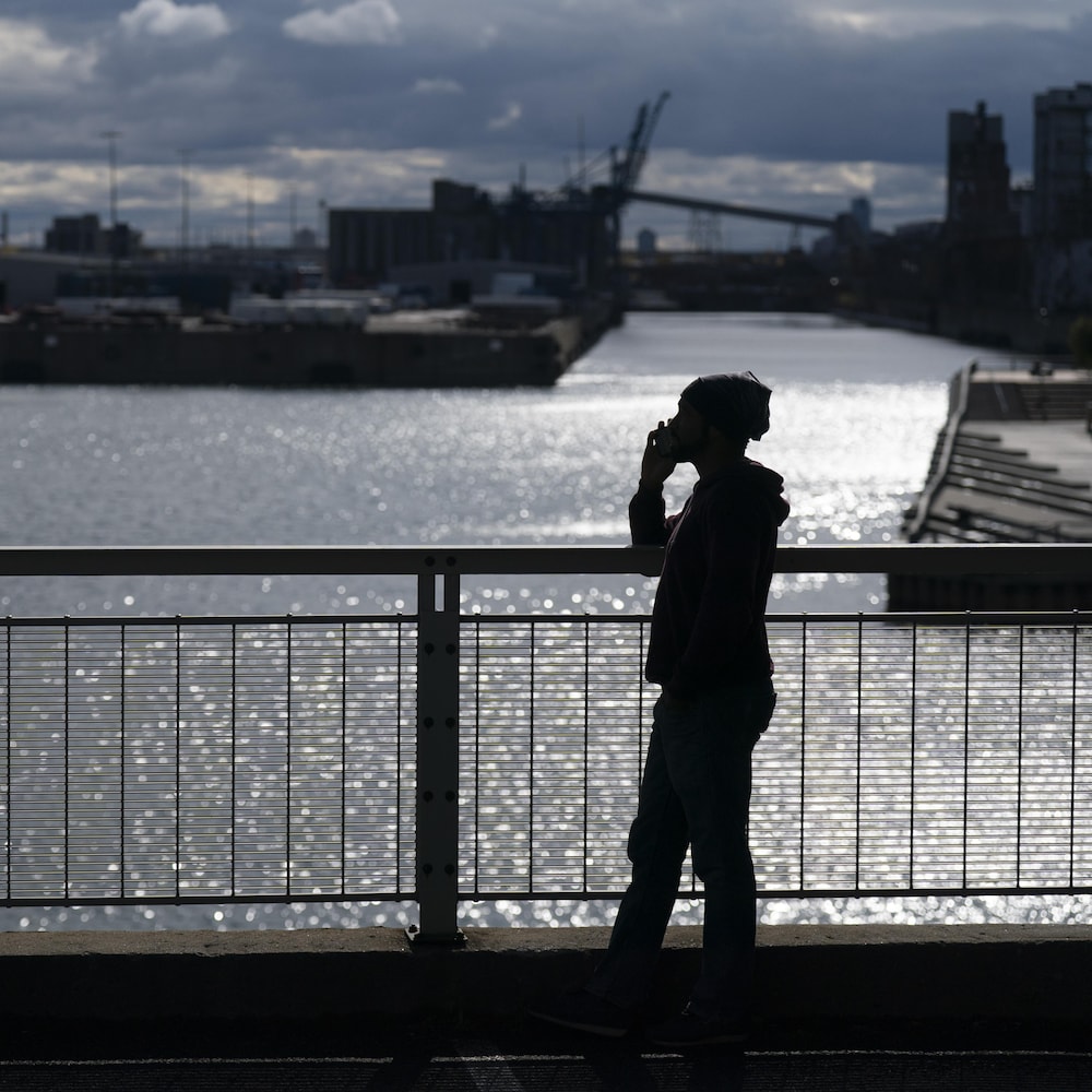 Un homme parle au téléphone près du fleuve.