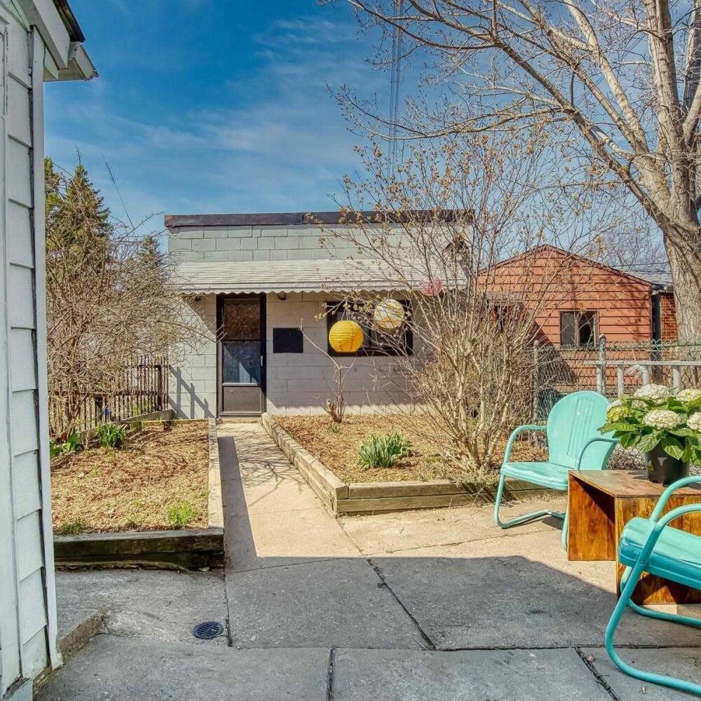 Un jardin avec une petite terrasse et un garage au bout.