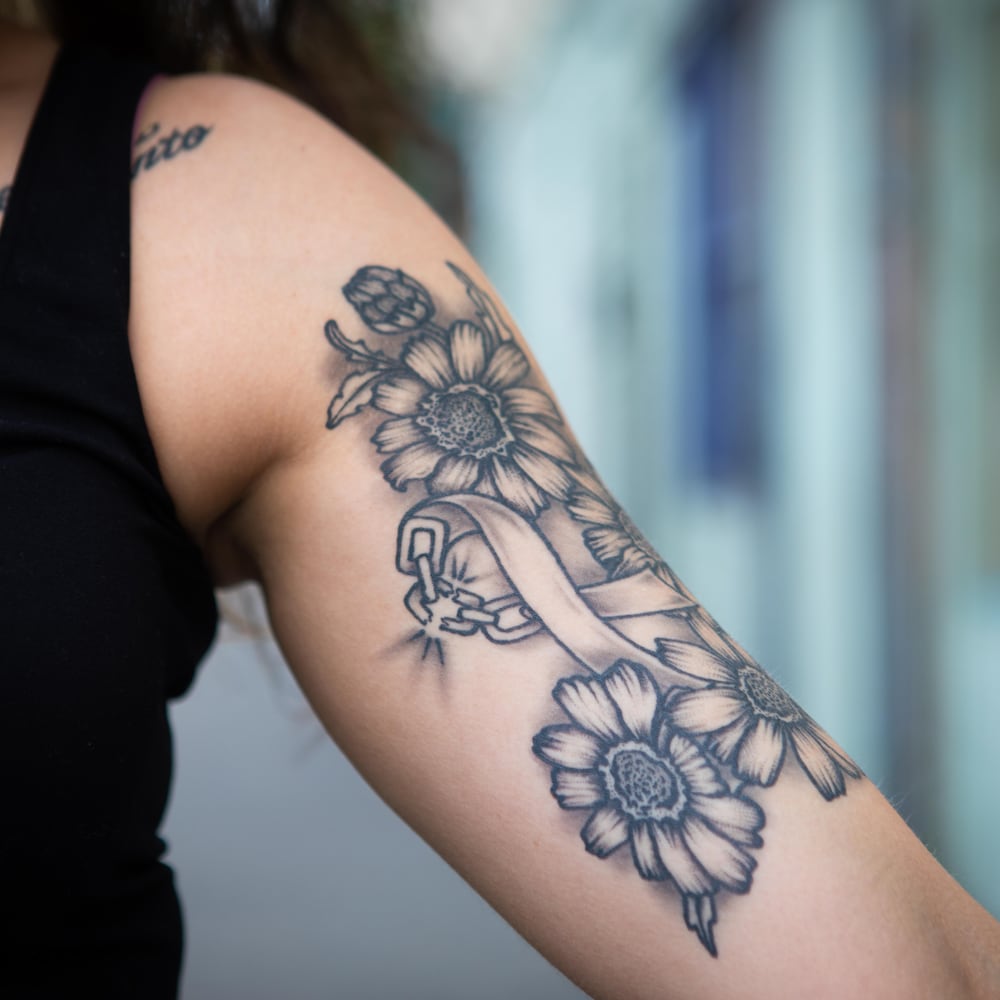 Un tatouage sur le bras de Tamara Straiton représente une chaîne brisée.