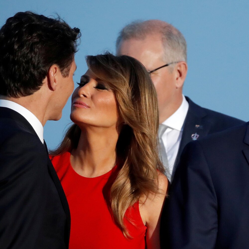 Justin Trudeau et Melania Trump s'embrassent sur les joues, alors que Donald Trump est à côté d'eux.
