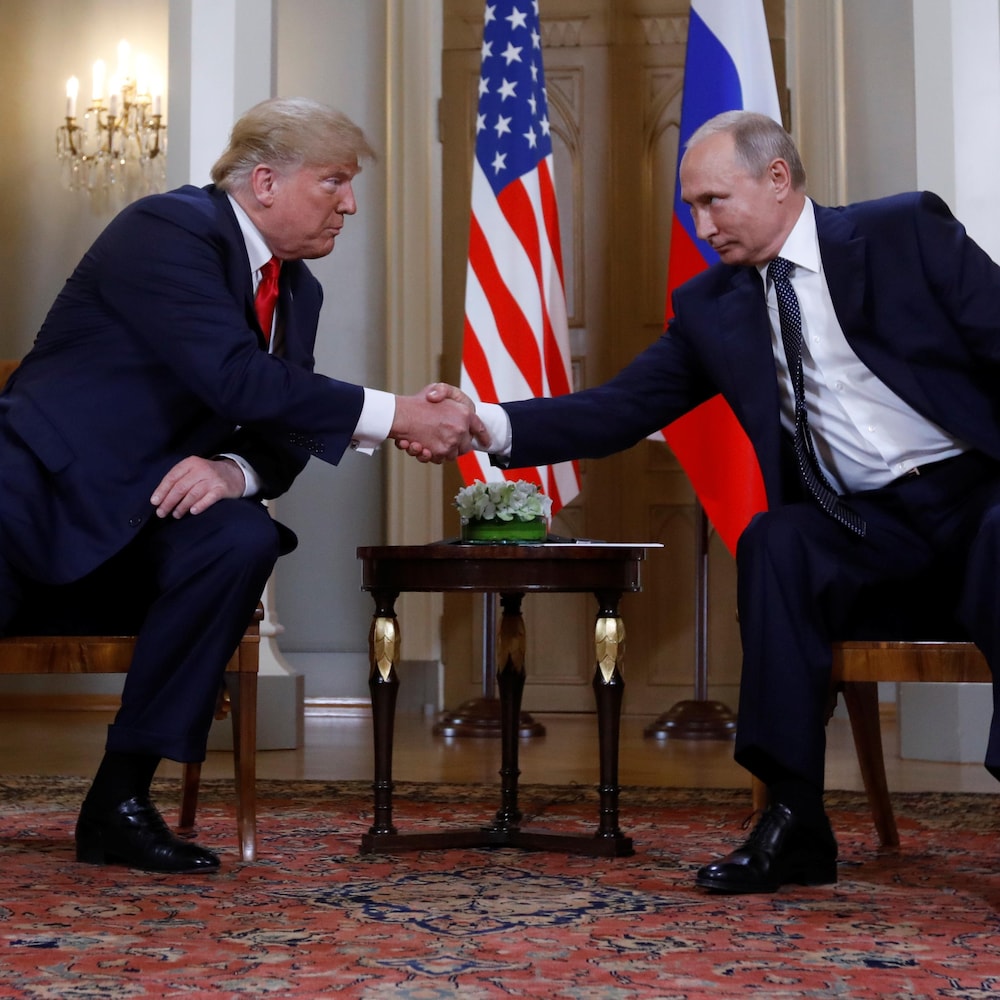 Donald Trump et Vladimir Poutine se penchent l'un vers l'autre pour se serrer la main.