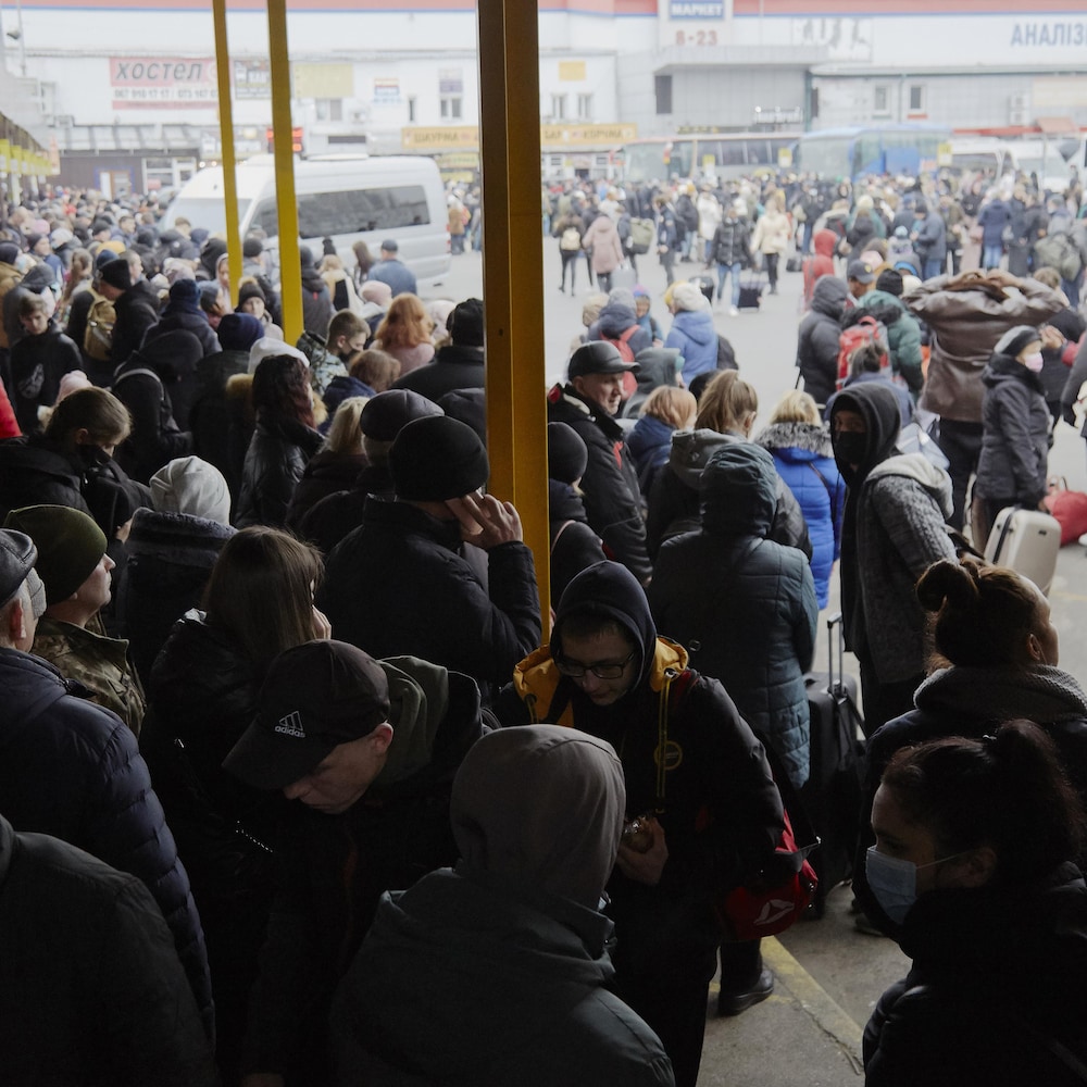 Une foule compacte dans un terminal d'autobus.
