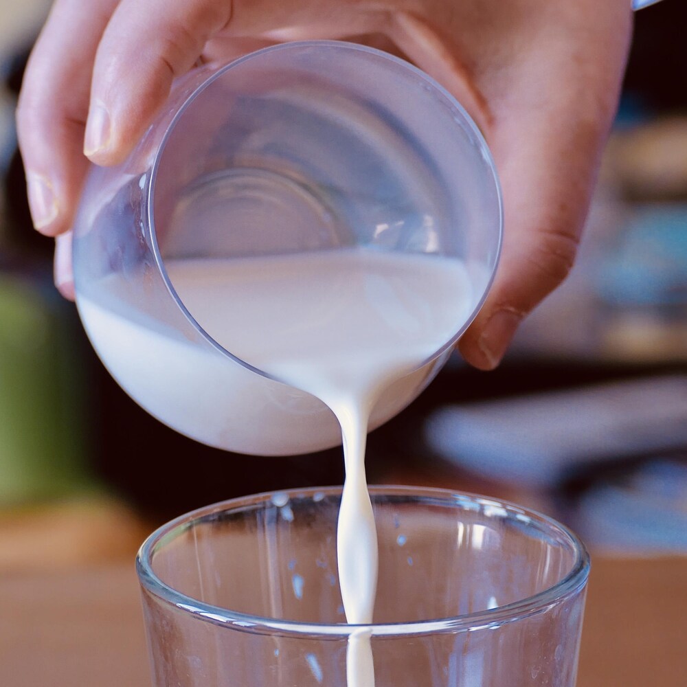 Du lait versé dans un verre.