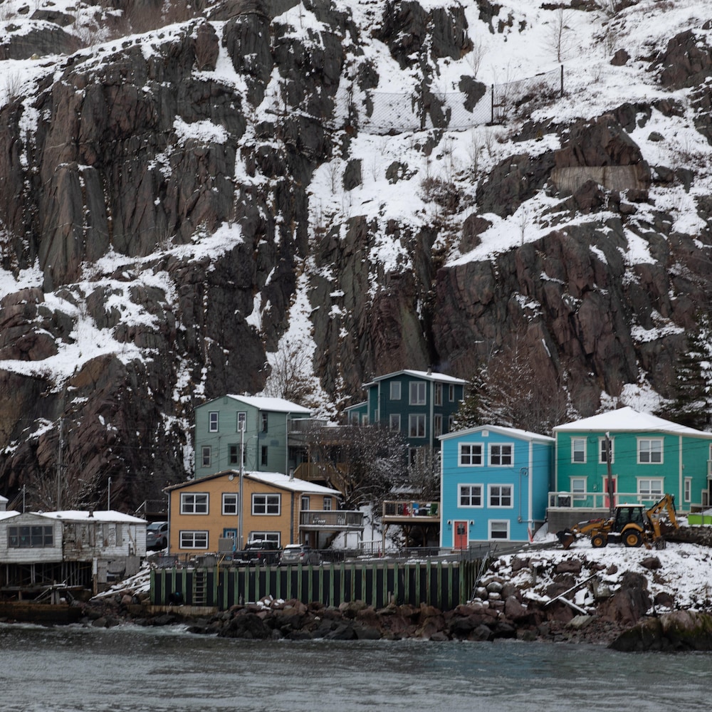 Des maisons colorées en bas d'une falaise.