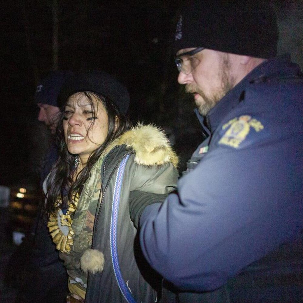 Une femme est escortée par des agents de la GRC.