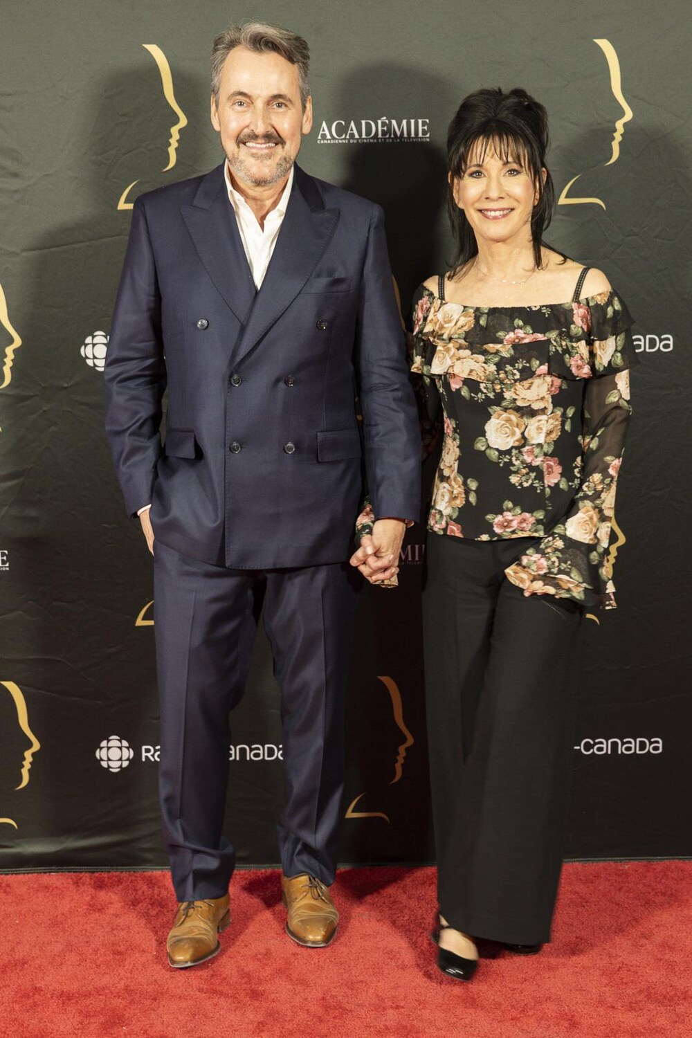 Radio-Canada / Paul Ducharme Photographe ACCT L'homme et la femme se tiennent la main et sourient sur le tapis rouge.